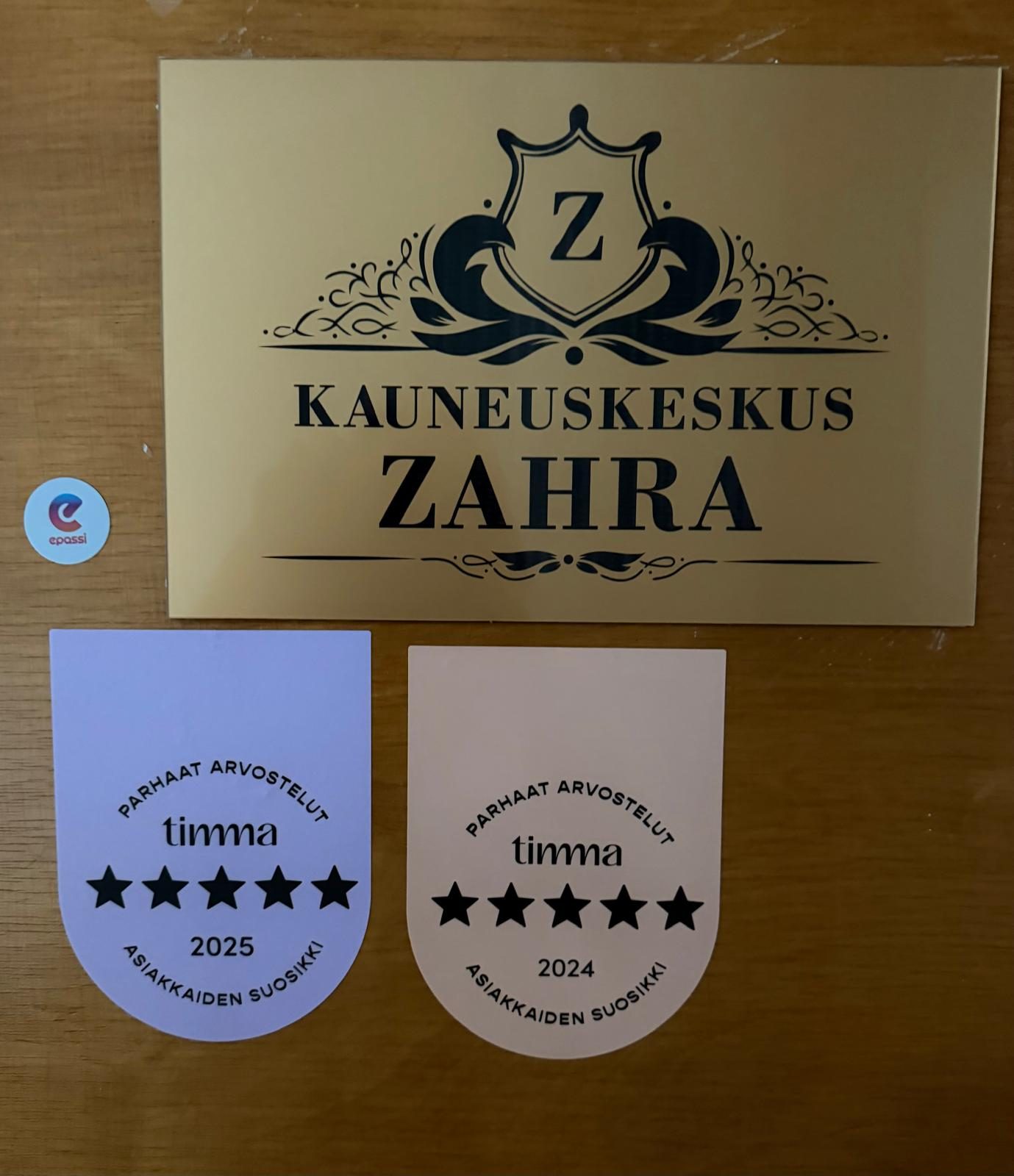 Hoitolan ovi: kultainen Kauneuskeskus Zahra -kyltti ja Timman tähtimerkit